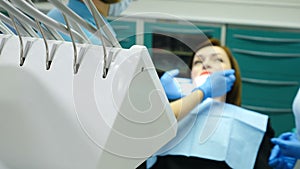 At dentist office. Female doctor treating patient who experiencing some jaw pain in joint. Young woman in dental chair