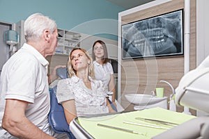 Dentist with patient and assistant
