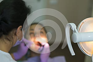 Dentist and patient in dentist office. Close-up of dental drill use for patient teeth in dentistry office in a dental treatment