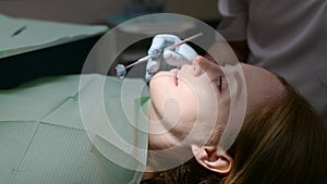 Dentist and patient at modern medical center. Doctor treats a young woman teeth in hospital