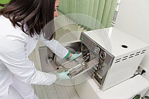 Dentist Places Medical Autoclave For Sterilising Surgical