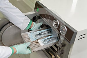 Dentist Places Medical Autoclave For Sterilising Surgical