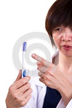 Dentist pointing at old worn out toothbrush bristle