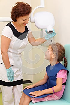 Dentist prepares girl to jaw x-ray image photo