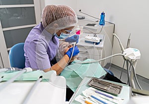 Dentist in the process of caries treatment