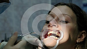 Dentist puts the cotton wool in the patient mouth and dries the teeth before installing the bracket system close-up