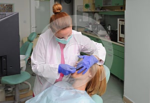 Dentist puts dental veneers patient and correction of teeth