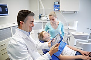 Dentist with x-ray on tablet pc and patient girl