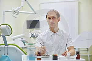 Dentist is ready to receive patients in his office, young male doctor