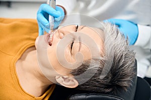 Dentist removing plaque and tartar buildup during professional hygienic cleaning