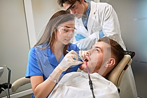 Dentist repairing tooth to male patient