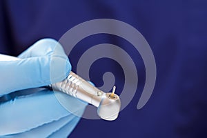 Dentist`s hand in glove with dental handpiece