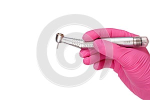 Dentist`s hand in glove with dental handpiece