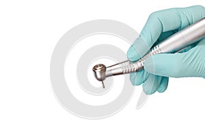 Dentist`s hand in glove with dental handpiece