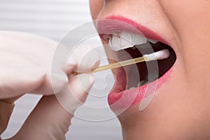 Dentist`s Hand Taking Saliva Test From Woman`s Mouth