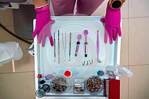 Dentist`s hands in gloves and dental treatment tools