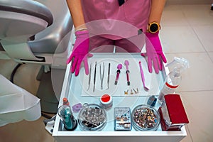 Dentist`s hands in gloves and dental treatment tools