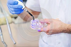 Dentist`s hands holding a dental lamp