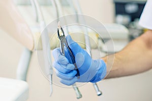 Dentist`s hands holding a dental lamp