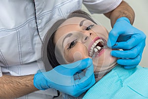 Dentist`s hands with teeth sampler and patient