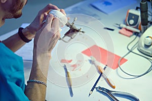 The dentist`s hands are working on making denture to replace the patient