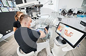 Dentist scanning patient's teeth with modern machine for intraoral scanning.