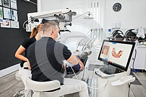 Dentist scanning patient's teeth with modern machine for intraoral scanning.