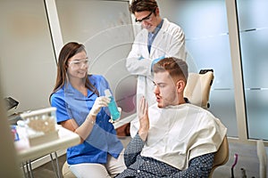 Dentist showing mouthwash to patient