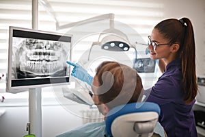 Dentist showing x-ray footage of teeth to patient