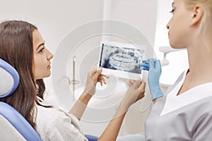 Dentist showing X-ray image to patient