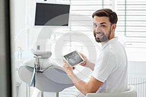 Dentist showing x-ray on tablet screen inmodern dental clinic