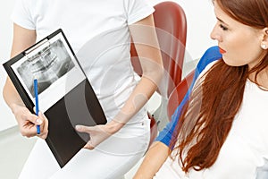 Dentist showing the X-ray to her client