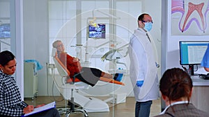 Dentist showing teeth x-ray reviewing it with nusre