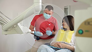 A dentist shows an orthodontic plastic jaw bite to a patient. Health treatment of enamel. photo