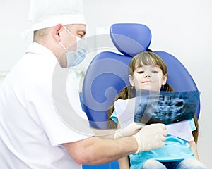 Dentist shows a patient x-ray of teeth