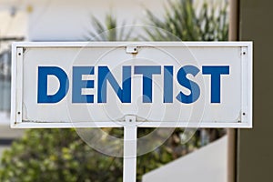 Dentist sign outside practitioner in bold blue and white