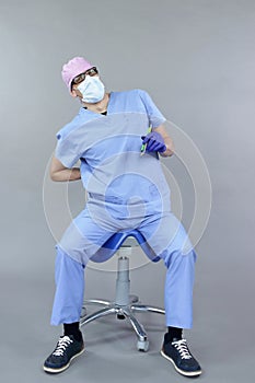 Dentist sitting on saddle suffering from lower back pain