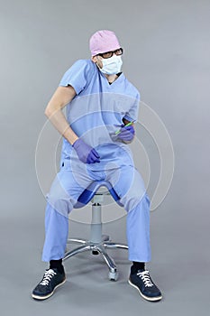 Dentist sitting on saddle suffering from  pain in shoulder