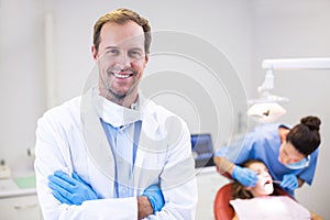 Dentist standing with arms crossed in clinic