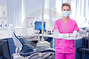 Dentist in surgical mask standing with arms crossed