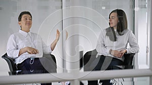 Dentist talking with young female patient in at the dentist clinic.