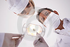 Dentist, team and portrait of people with light for consulting, teeth whitening and wellness. Healthcare, dentistry and