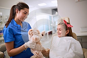 Dentist with teddy bear relaxing child