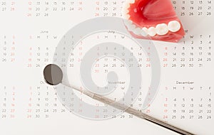 Dentist tool and demonstration teeth model on calendar