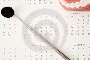 Dentist tool and demonstration teeth model on calendar