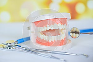 Dentist tools with dentures dentistry instruments and dental hygienist checkup concept with teeth model and mouth mirror oral