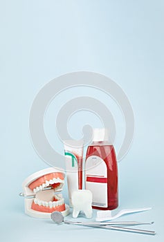 Dentist tools toothbrush, toothpaste and Dental Teeth Model dentures on Blue background. Dental equipment. Dental Care conceptual