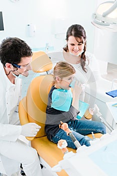 Dentist treating child in his surgery