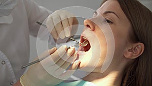 Dentist treating teeth to woman patient in clinic. Female professional doctor at work. Dental checkup