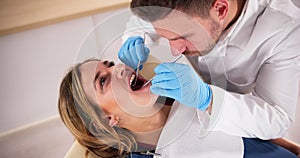 Dentist Treating Teeth Of Young Pregnant Woman Patient Lying